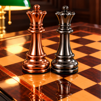 Deux reines d’échecs, l’une cuivre et l’autre gris acier, sur un échiquier en bois brillant.