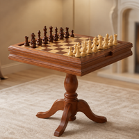 Échiquier en bois sur pied avec pièces claires et foncées disposées sur le plateau, présenté dans un intérieur chaleureux aux tons beige et bois.